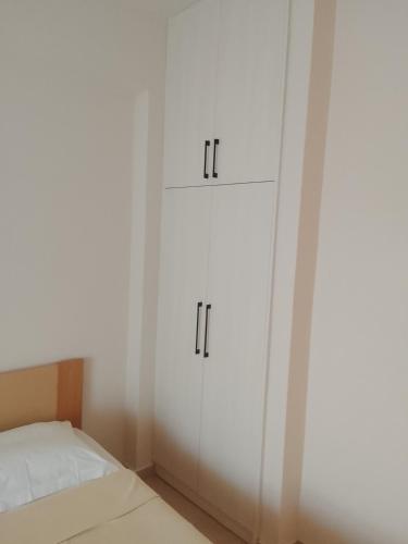 a bedroom with white cabinets and a bed at ΔΙΑΜΈΡΙΣΜΑ ΜΕΝΤΗΣ in Igoumenitsa