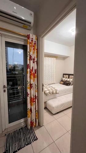 a bedroom with a bed and a sliding glass door at A Simple stay at SpringLake Apartment, Bekasi in Rawabugel