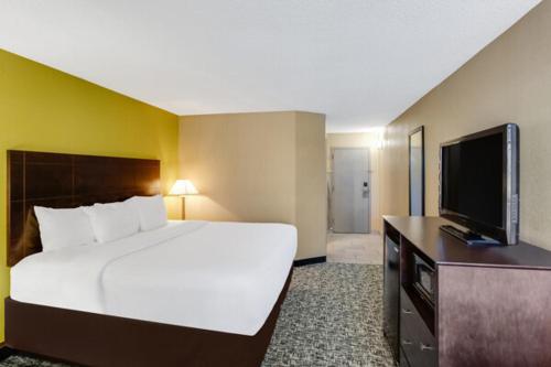a bedroom with a large bed and a flat screen tv at Clarion Inn Asheville Airport in Fletcher
