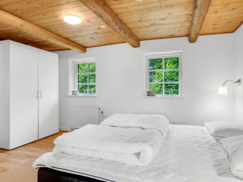a white room with two beds and two windows at Holiday Home Åsta - 400m to the fjord by Interhome in Roslev