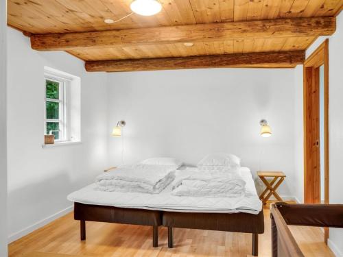 a bed in a room with a wooden ceiling at Holiday Home Åsta - 400m to the fjord by Interhome in Roslev