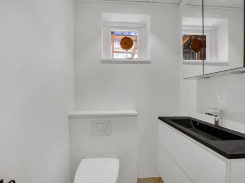 a white kitchen with a sink and a toilet at Holiday Home Abel - 250m from the sea by Interhome in Strøby