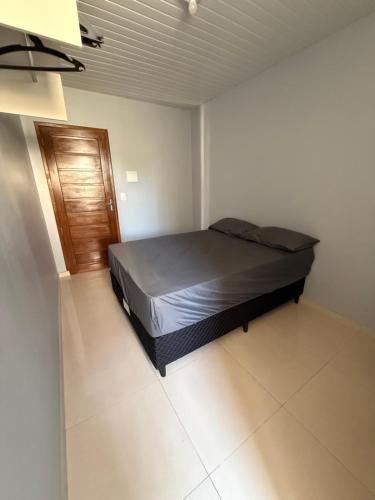 a bedroom with a bed and a wooden door at Hospedaria Tapajós in Santarém