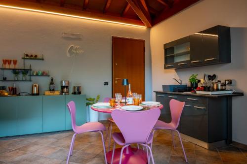 a kitchen with a table and purple chairs in a kitchen at Da Gise Giardino Wifi Malpensa in Somma Lombardo