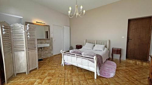 a bedroom with a white bed and a bathroom at Fayollas in Bussière-Galant