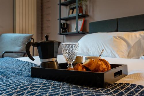 a tray of bread and affeepot on a bed at Da Gise Giardino Wifi Malpensa in Somma Lombardo