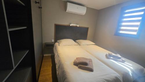 OffingawierにあるCastalia Houseboat met uitzicht over het Sneekermeerのベッドとタオル2枚のある寝室