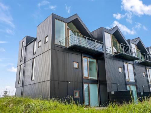 ein schwarzes Gebäude mit Balkon auf der Seite in der Unterkunft Holiday Home Anita - 575m from the sea by Interhome in Skagen