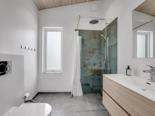 a bathroom with a shower and a toilet and a sink at Holiday Home Apelone - 900m from the sea by Interhome in Marielyst