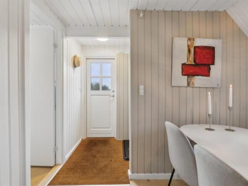 a dining room with a white table and chairs at Holiday Home Svenne - 1-4km from the sea by Interhome in Tranekær