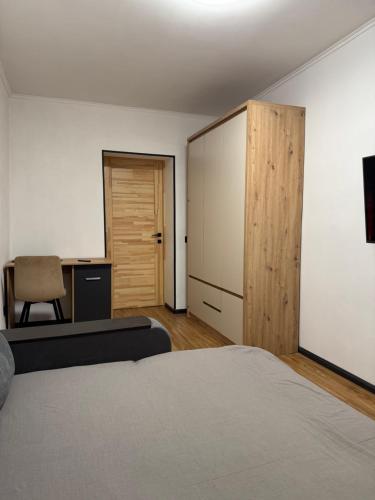 a bedroom with a bed and a desk and a chair at Затишні апартаменти для Вас in Uzhhorod