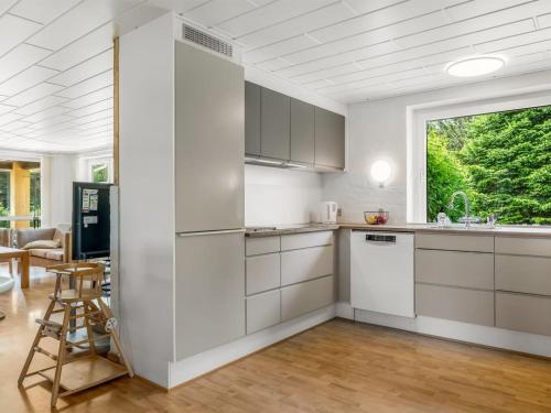 a kitchen with white cabinets and a large window at Holiday Home Ebon - from the sea by Interhome in Hals