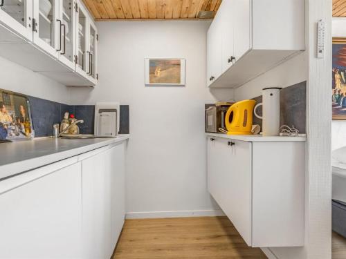 a kitchen with white cabinets and white counters at Apartment Økil - 2km from the sea by Interhome in Skagen