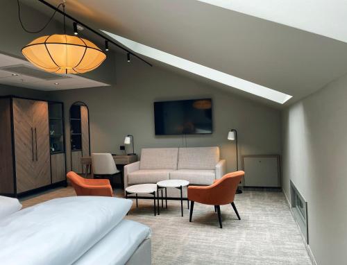 a room with a bed and a couch and a table at Karl Johan Hotel in Oslo
