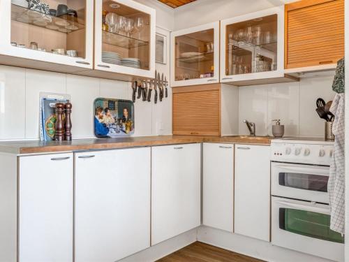 een witte keuken met houten kasten en witte apparaten bij Apartment Sibyll - 2km from the sea by Interhome in Skagen