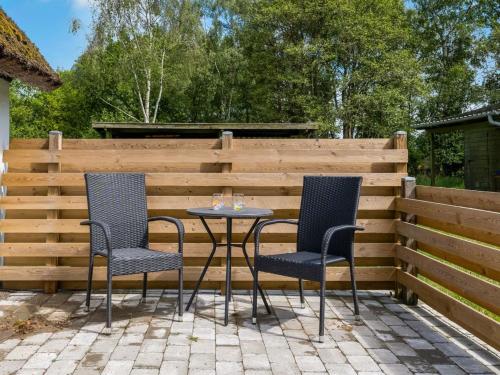 two chairs and a table in front of a fence at Holiday Home Aatos - 2km from the sea by Interhome in Læsø