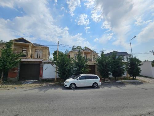 a white car parked in front of some houses at Lush Paradise villa BHM in Gabala