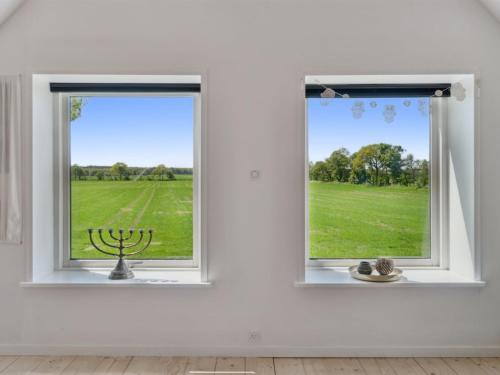 two windows in a white room with a view of a field at Holiday Home Aarni - 6-5km from the sea by Interhome in Gudhjem