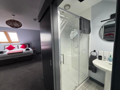 a bathroom with a shower and a sink and a bed at Vestley Banks in Orkney