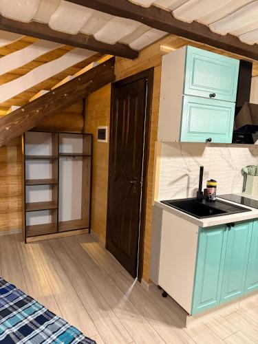 a kitchen with blue cabinets and a sink in a room at Гірські Будиночки in Synevyrsʼka Polyana