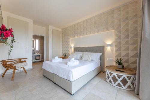 a bedroom with a large white bed and a table at Villa Regina Sul Mare in Torre Santa Sabina