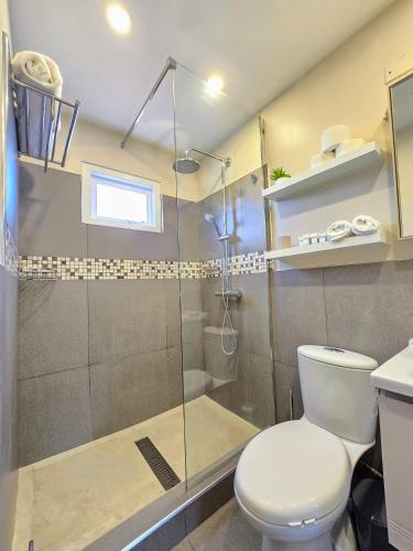 a bathroom with a toilet and a glass shower at Bubali Residence in Palm-Eagle Beach