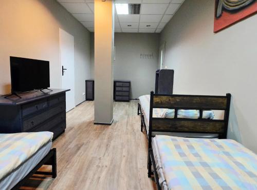 a room with two beds and a flat screen tv at Lipowa Guest House in Bielawa