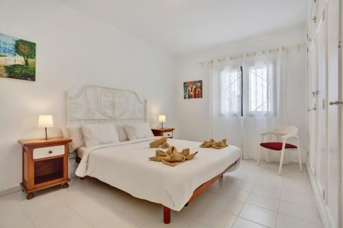 una camera bianca con un grande letto bianco con fiori di Casa Queen Vetusta a Argana