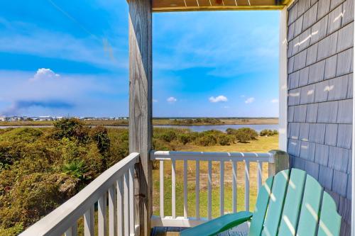 a porch with a chair and a view of the ocean at Turtle Cove in North Topsail Beach