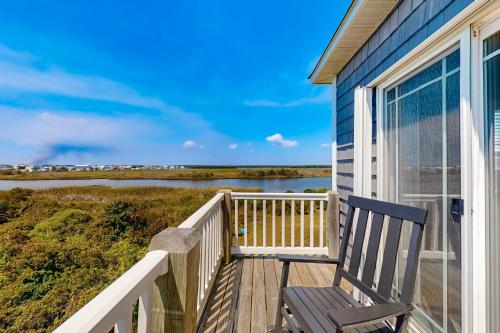 a porch with a bench on the side of a house at Turtle Cove in North Topsail Beach