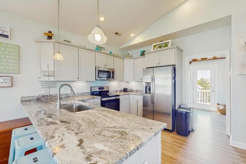 a kitchen with white cabinets and a marble counter top at Turtle Cove in North Topsail Beach