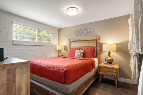 a bedroom with a red bed and a window at Downtown Cozy Home Base - Purple Sage 1 in Moab