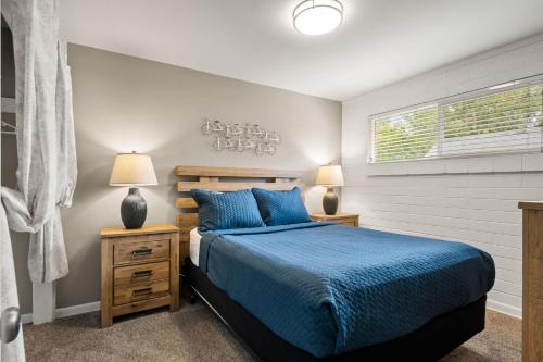 ein Schlafzimmer mit einem Bett und zwei Lampen und einem Fenster in der Unterkunft Downtown Cozy Home Base - Purple Sage 4 in Moab
