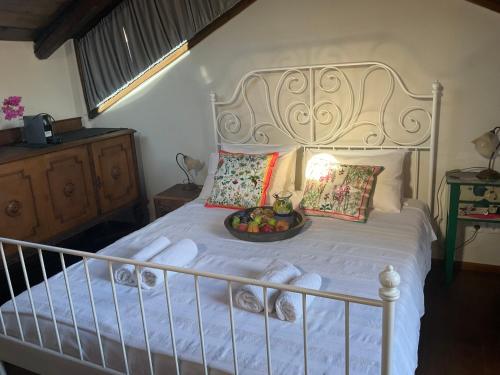 a white bed with a bowl of fruit on it at Happy Place in Rethymno