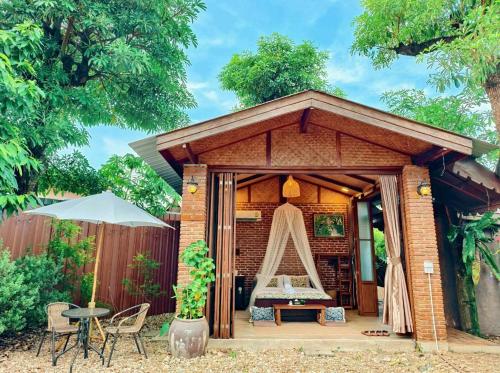 a small pavilion with a table and chairs at เติมชีวา Barcafe & Guesthouse in Chiang Rai