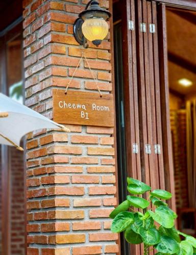 a brick wall with a sign for cheney room at เติมชีวา Barcafe & Guesthouse in Chiang Rai