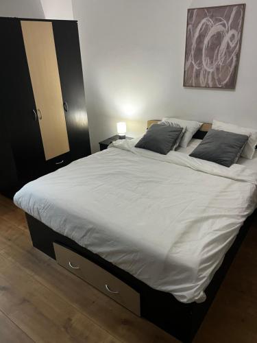 Un dormitorio con una cama grande con sábanas y almohadas blancas. en VF Apartments, en Bucarest