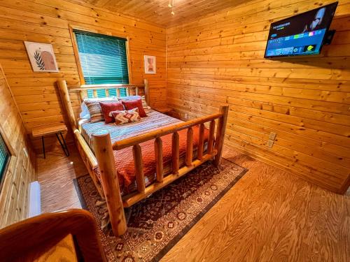 a room with a bed in a log cabin at Logged Out in Piney Creek