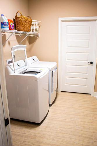 a washer and dryer in a room with a door at Fully Furnished 3BR Subdivision Amenities in Warner Robins
