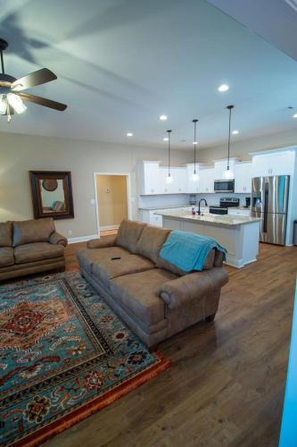 a living room with a couch and a kitchen at Fully Furnished 3BR Subdivision Amenities in Warner Robins