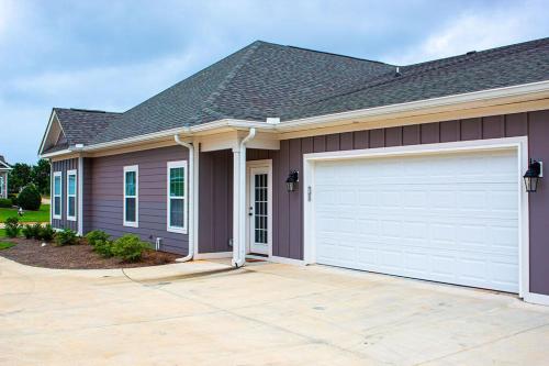 a brown house with a white garage at Fully Furnished 3BR Subdivision Amenities in Warner Robins