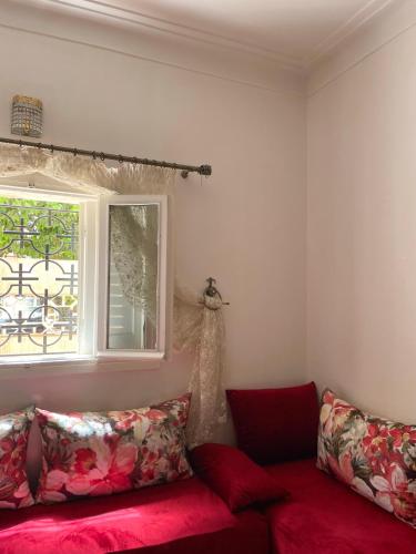a living room with a red couch and a window at Appartement spacieux avec jardin in Safi