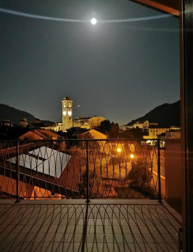 a view of a city at night with the moon at Appartamenti Del Borgo in Borgosesia