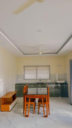 a kitchen with a wooden table and a bench at Le SAFFRON in Padinjarathara