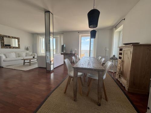 Una mesa de comedor y sillas en una sala de estar. en Le Balcon de Tresmeur, en Bonne Nouvelle