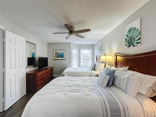 Un dormitorio con dos camas y un ventilador de techo. en Parkway Palms Resort 1 bed condo mins to Disney., en Orlando