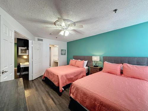 Un dormitorio con dos camas y un ventilador de techo. en Two bed condo in Parkway Palms Resort, en Orlando