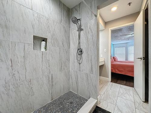 baño con ducha y cama roja en Two bed condo in Parkway Palms Resort, en Orlando