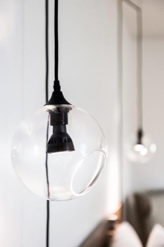 a glass light fixture hanging from a wall at C3- Hotel Art De Vivre in Quebec City