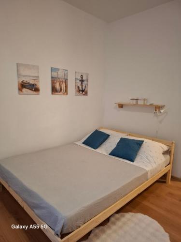 un letto in una camera con due immagini sul muro di City Studio Ana a Fiume (Rijeka)